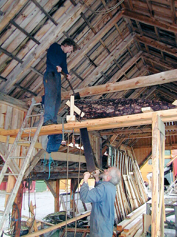 Two builders use the long saw