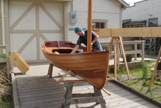 A student puts the finishing touches on the Sid skiff