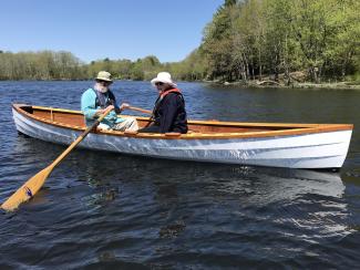 17' LOA Cape Split Peapod, in water being rowed