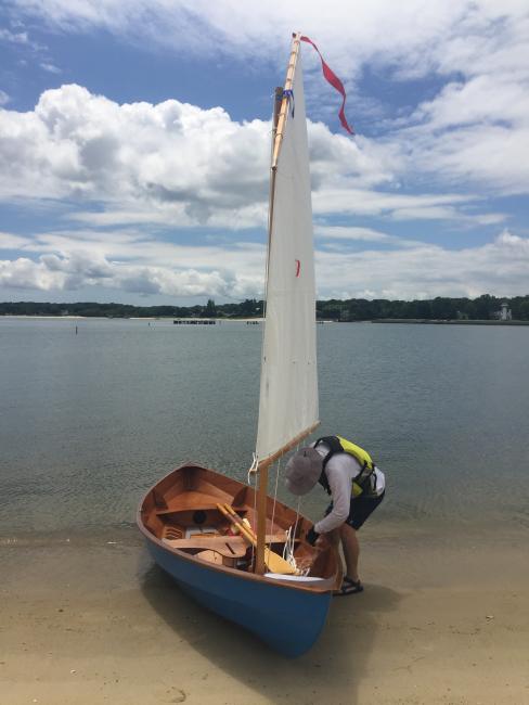 Chesapeake Light Craft Skerry, sail up, clouds, water, ready to launch