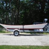Custom wooden row boat, on trailer, starboard side view