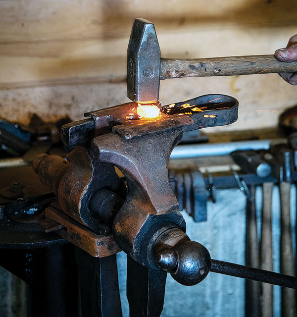 Using hammer blows to force the heated iron into the molded surface of the swage.
