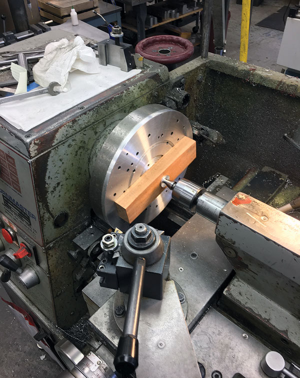 Med uses a vise-held spring swage to shape the head of the iron.