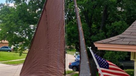 FAMILY TIME at home on trailer with sails full and US flag in front driveway.