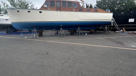 Classic wooden twin diesel cruiser, on the hard port side view