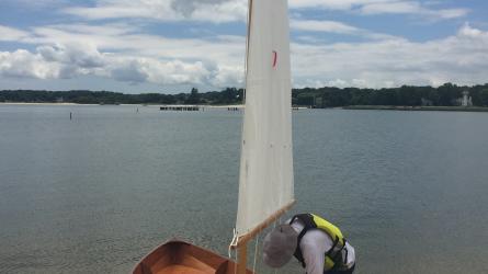 Chesapeake Light Craft Skerry, sail up, clouds, water, ready to launch