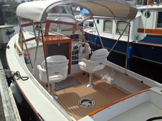 Cockpit with pedestal seats and synthetic teak flooring.