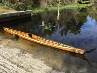 Strip-built Wahoo Fast Sea Kayak on the shore.