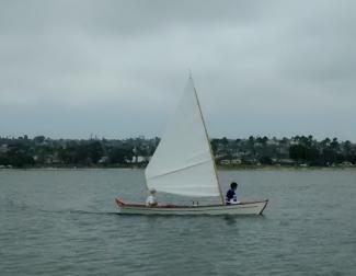 Sharpie skiff under sail.