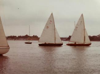 1920 Herreshoff S Boat in need of restoration , in water view from afar starboard side next to it's twinsie