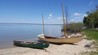 19' 7" Ketch Rigged Sailboat, settled on beach, water blue skies