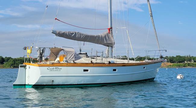 Cold-molded sloop Ceol Mor for sale, on mooring in water, starboard side stern end view