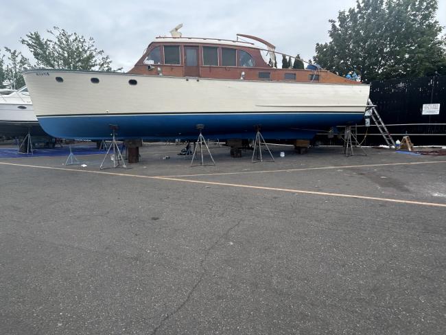 Classic wooden twin diesel cruiser, on the hard port side view