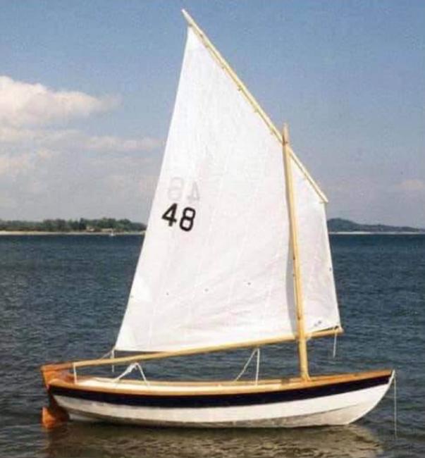 SHELLBACK SKIFF, in water sails up starboard side view