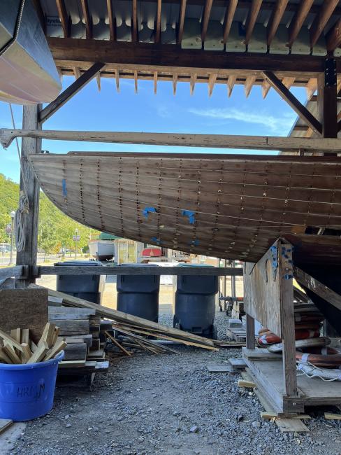 Wooden ballast keel sloop "RASCAL", on stands inside port side view, bowend