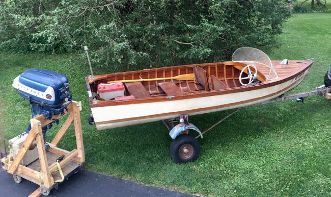 Boat built in 1958, Evinrude big twin motor, electric start, on trailer on the hard
