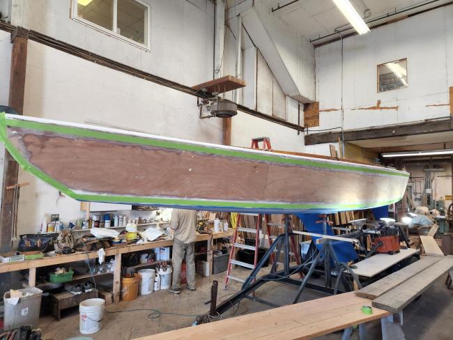 International 210 Hull No. 228 Restoration Complete, inisde shop being worked on port side view