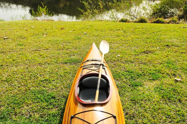 Wooden Kayak Miramichi 17'  - 1 person, up close photo on grass with paddle