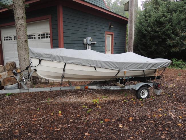 Penobscot 13 wooden sailboat, on trailer, covered, port side view